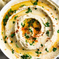 hummus in a white bowl topped with parsley