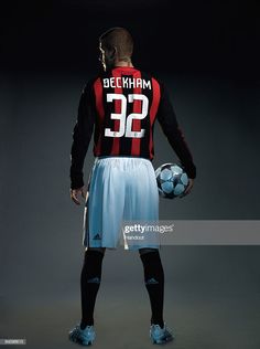 a man holding a soccer ball in his right hand and wearing a jersey with the number 32 on it