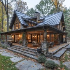 a large house in the woods with stone steps leading up to it