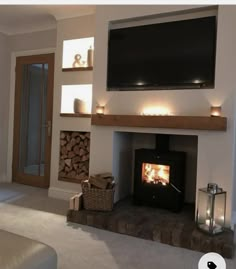 a living room with a fire place and television on the wall above it's mantle