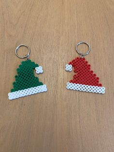 two christmas themed key chains sitting on top of a wooden table