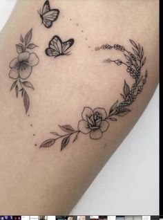 a tattoo with flowers and butterflies on it