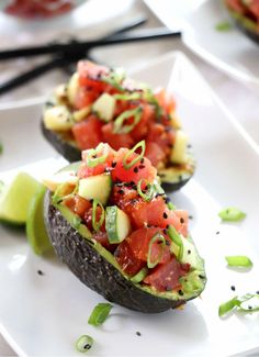 avocado stuffed with tomatoes, cucumber and black pepper on a white plate