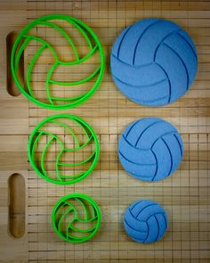 three different types of plastic volleyballs on a bamboo mat with holes for them to be cut out