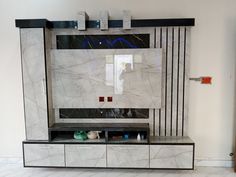 a large white marble tv stand in a living room with black and silver trimmings