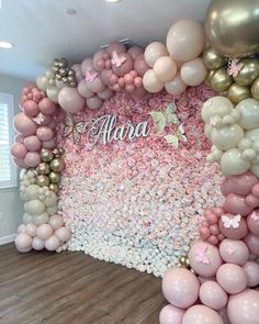 there is a wall made out of pink and gold balloons with the word aluna on it