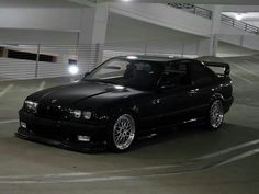 a black car parked in a parking lot at night