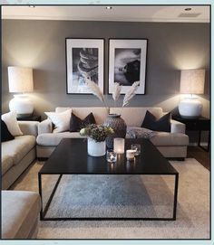 a living room filled with furniture and two pictures on the wall above it's coffee table