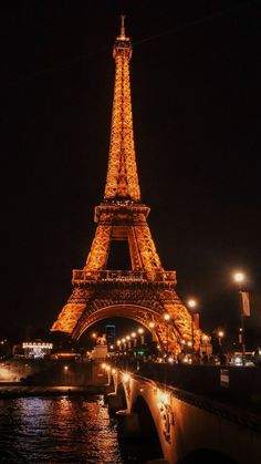 the eiffel tower lit up at night with lights on it's sides