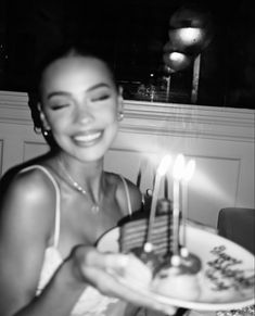 a woman holding a cake with candles on it