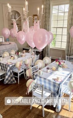 a room filled with tables and chairs covered in pink balloons