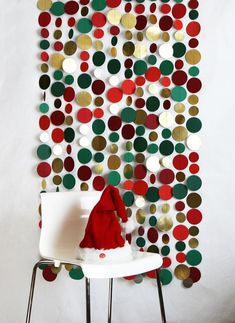 a white chair sitting in front of a wall with circles on it and a santa hat