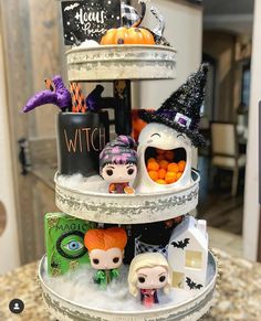 a three tiered halloween cake with figurines on top