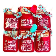 red oven mitts decorated with christmas sayings and blue ribbon tied around the handles