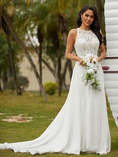 a woman in a wedding dress standing next to a large white balloon with flowers on it