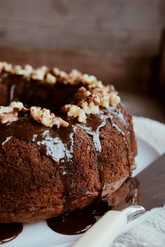 a chocolate bundt cake sitting on top of a white plate