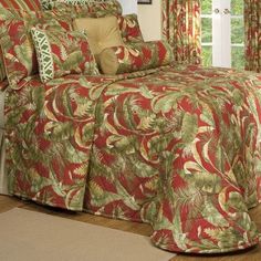 a bed with red and green bedspread in a bedroom next to a window