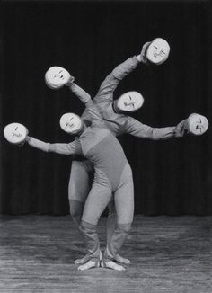 two people are balancing on their hands with balls in the shape of four heads and arms