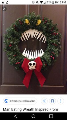 a wreath decorated with fake teeth and red bow hanging on the front door for halloween