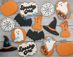 decorated halloween cookies on a wooden table with the words boozie one spelled in black and orange