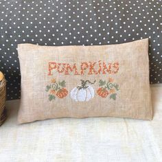 an embroidered pillow with pumpkins on it and the words pumpkins written in orange