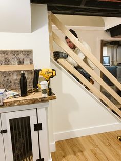 a man is working on an unfinished stair case in a house with wood flooring