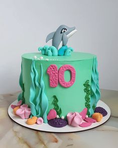 a birthday cake with an ocean theme and dolphin on the top is for someone's 10th birthday