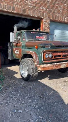 an old truck parked in front of a garage