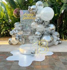 a table topped with silver and white balloons