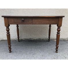 an old wooden table with one drawer on the top and two legs at the bottom