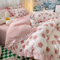 there is a bed with pink and white sheets on it, along with two stuffed animals