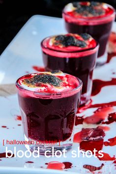 three glasses filled with blood sitting on top of a white table covered in red liquid