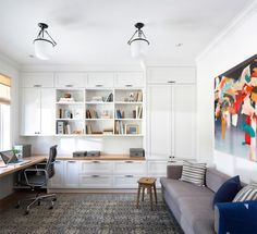 a living room filled with furniture and bookshelves next to a painting on the wall