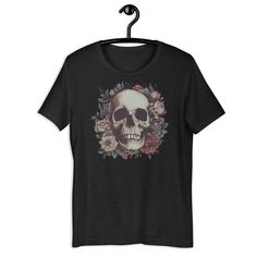 Skull Floral - Everyone needs the perfect t-shirt to complement an everyday, laid-back look. The ideal top for so many occasions, this lightweight cotton tee will keep you comfy and looking smart. * 100% combed and ring-spun cotton (Heather colors contain polyester) * Fabric weight: 4.2 oz/yd² (142 g/m²) * Pre-shrunk fabric * Side-seamed construction * Shoulder-to-shoulder taping * Blank product sourced from Guatemala, Nicaragua, Mexico, Honduras, or the US This product is made especially for yo Punk Skull Print T-shirt For Summer, Cotton Grunge T-shirt With Skull Print, Punk Skull T-shirt For Summer, Summer Punk Skull T-shirt, Summer Punk T-shirt With Skull Design, Edgy Skull Print Relaxed Fit T-shirt, Summer Band Merch T-shirt With Skull Print, Punk Style T-shirt With Skull Print And Relaxed Fit, Cotton Rocker Tops With Skull Print