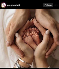 two people holding their hands together to show the baby's feet in its mother's lap