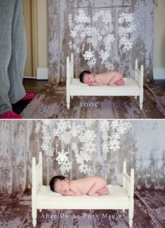 a baby laying on top of a bed with snowflakes hanging from the ceiling