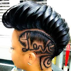 the back of a woman's head with braids and love written on it