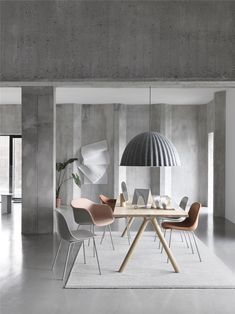 a dining room table with chairs and a lamp in the corner, next to a white rug