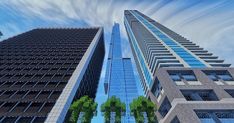 two tall buildings next to each other with trees in the foreground and clouds in the background