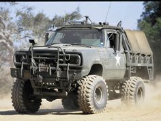 an army truck driving down a dirt road