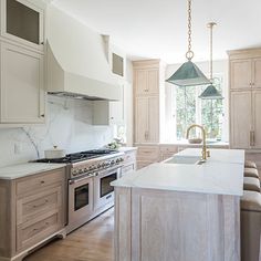 a kitchen with an island, stove and oven in the middle of it's center island