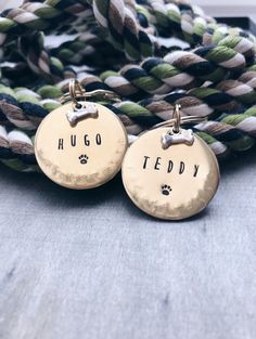 two personalized dog tags are attached to a rope with the word hug teddy on it