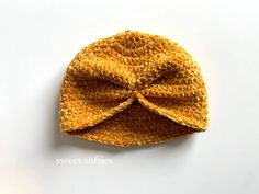 a close up of a knitted hat on a white surface