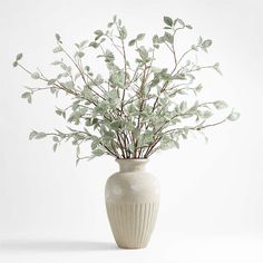 a white vase with some green leaves in it