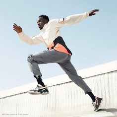 a man riding a skateboard up the side of a cement wall with his arms out