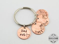 three personalized copper key chains with the words dad est mat and hearts on them