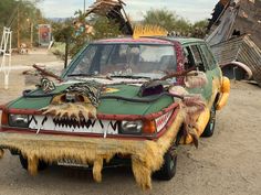 an odd looking car is parked in the dirt