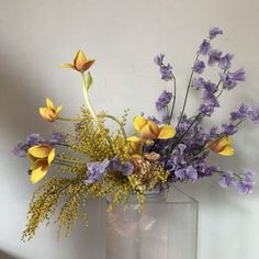 a vase filled with yellow and purple flowers