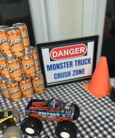 a table topped with monster trucks next to orange cones