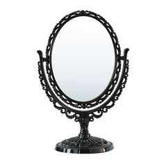 an ornate black vanity mirror sitting on top of a table